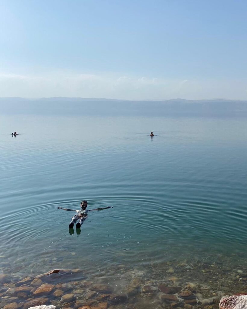 ヨルダンの死海で泥パックをしながら浮かぶ女性